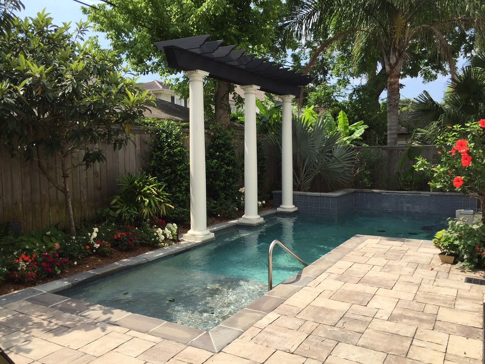 Imagen de piscina con fuente alargada clásica de tamaño medio rectangular en patio trasero con adoquines de piedra natural