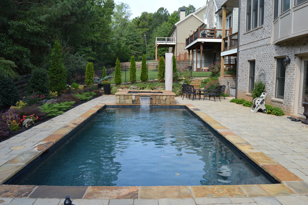 Imagen de piscina con fuente natural tradicional pequeña rectangular en patio trasero