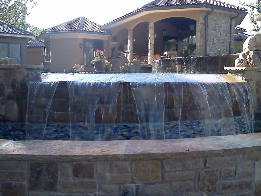 This is an example of a large world-inspired back custom shaped swimming pool in Kansas City with natural stone paving.