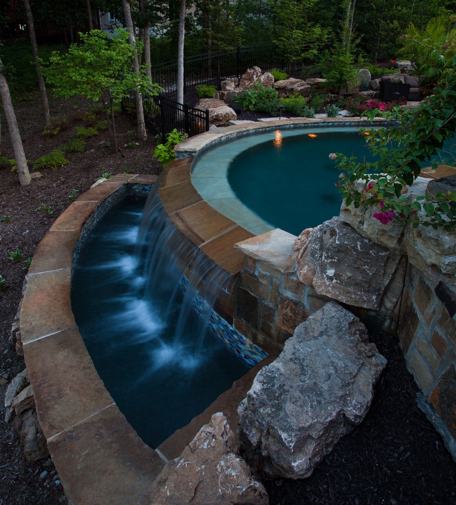 Pool - large tropical backyard stone and custom-shaped pool idea in Kansas City