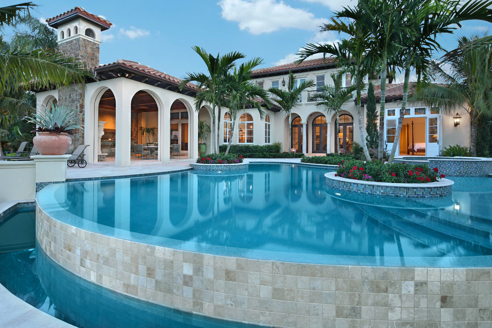 Foto di una piscina a sfioro infinito mediterranea personalizzata di medie dimensioni e dietro casa con piastrelle