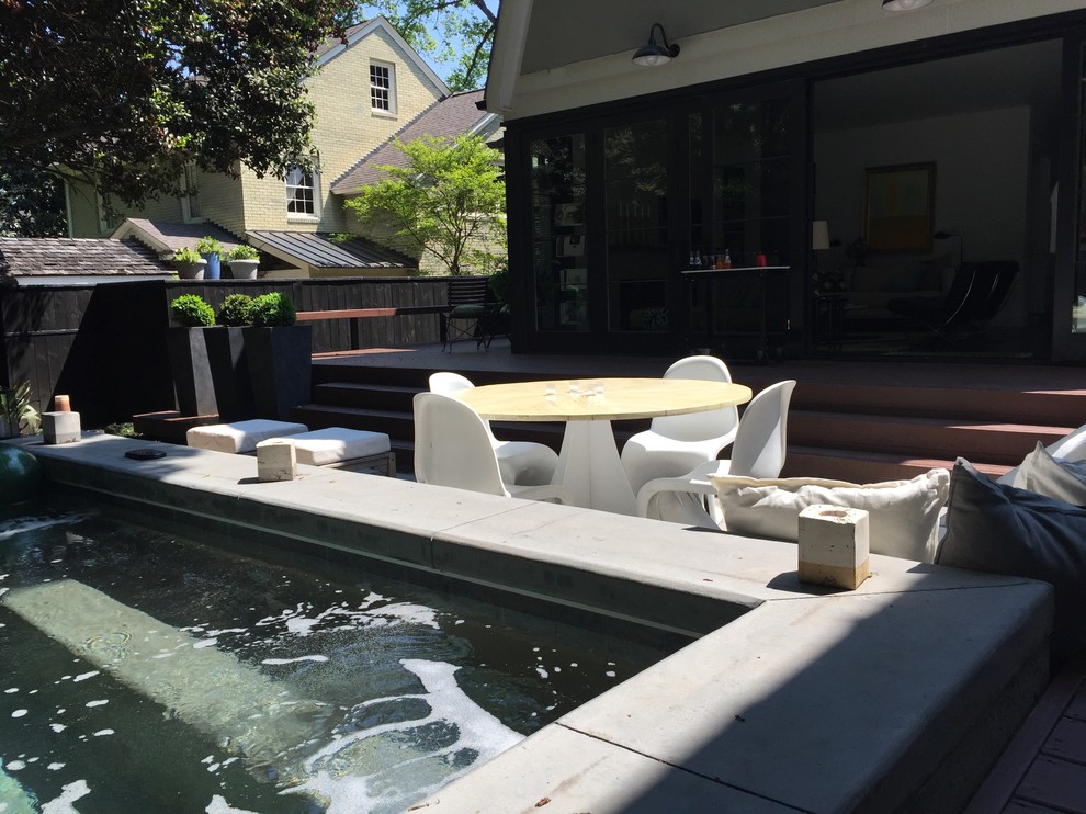 Aménagement d'une petite piscine arrière moderne rectangle avec un bain bouillonnant et une terrasse en bois.