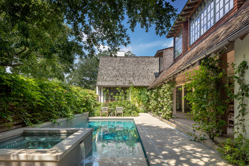 На фото: большой естественный, прямоугольный бассейн на боковом дворе в классическом стиле с джакузи и покрытием из бетонных плит