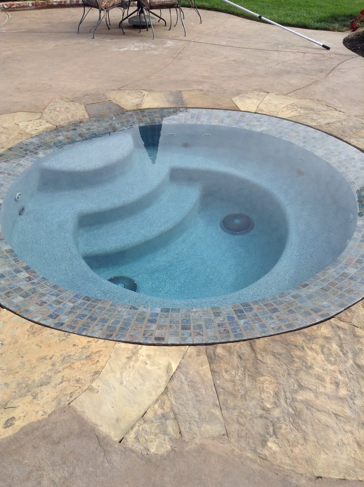 Foto di una piscina a sfioro infinito stile rurale personalizzata dietro casa con fontane e cemento stampato