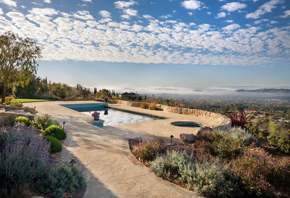 Idee per una grande piscina a sfioro infinito mediterranea rettangolare dietro casa con una vasca idromassaggio