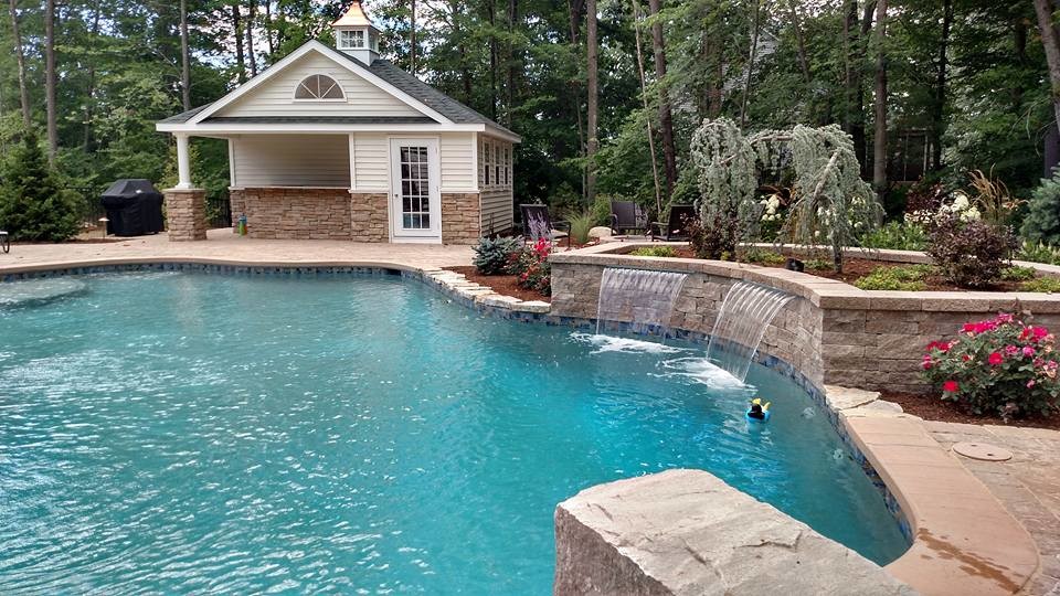 Ejemplo de piscina con fuente natural de estilo americano de tamaño medio a medida en patio trasero con adoquines de hormigón