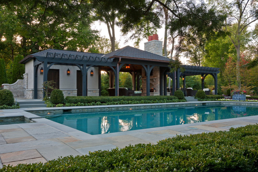 Foto di una piscina chic rettangolare di medie dimensioni e dietro casa con una dépendance a bordo piscina e pavimentazioni in pietra naturale