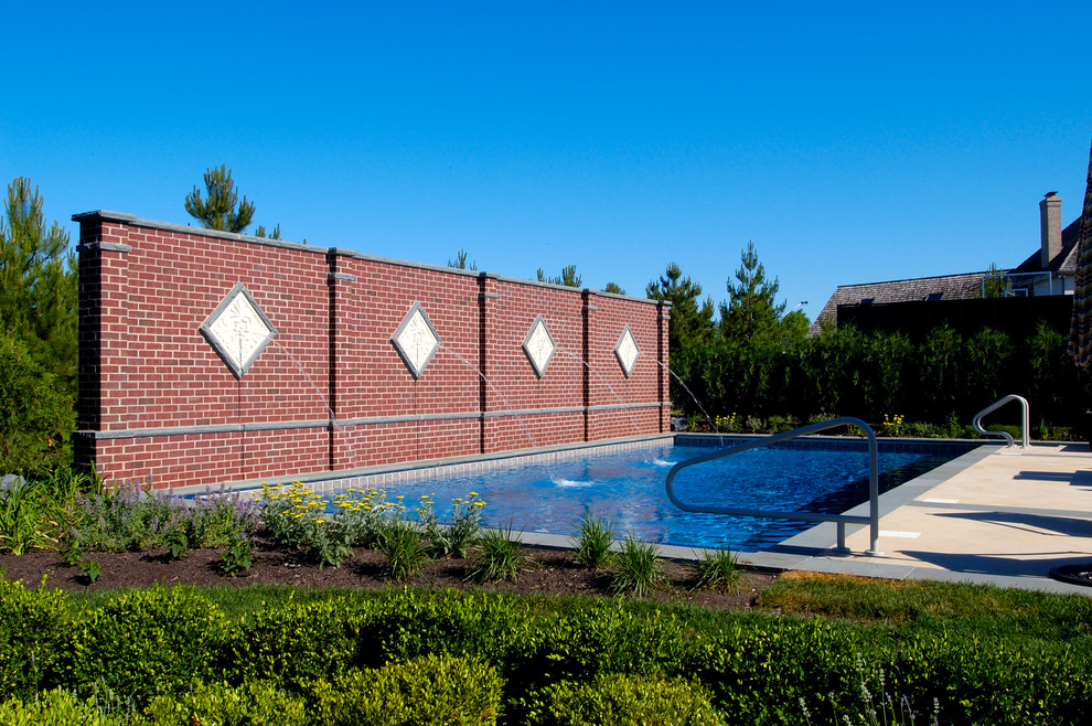 Immagine di una piscina monocorsia mediterranea rettangolare di medie dimensioni e dietro casa con pavimentazioni in pietra naturale