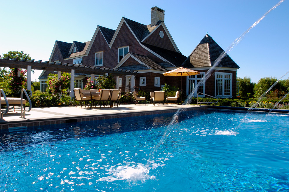 Imagen de piscina alargada mediterránea de tamaño medio rectangular en patio trasero con adoquines de piedra natural