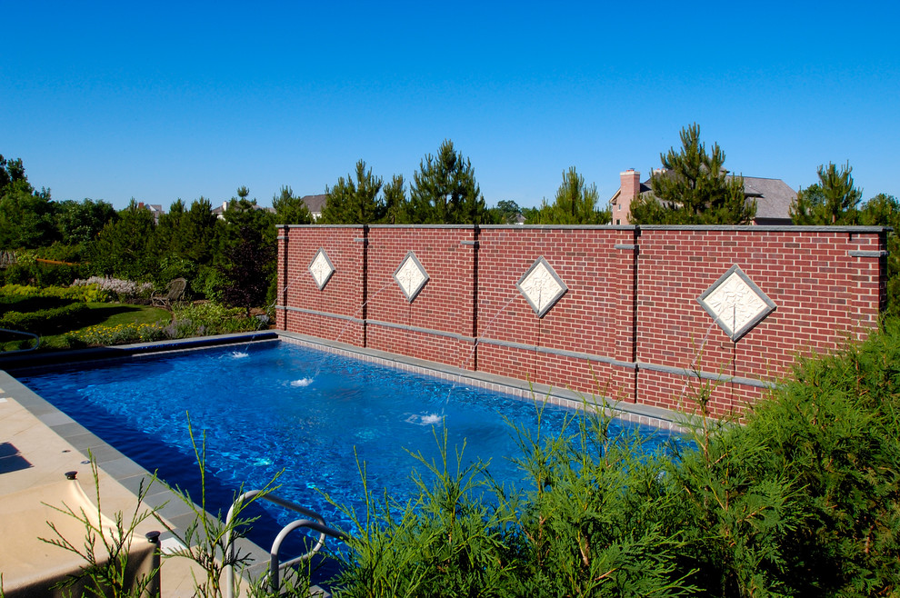 Photo of a medium sized mediterranean back rectangular lengths swimming pool in Chicago with natural stone paving.