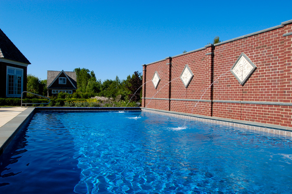 Imagen de piscina alargada mediterránea de tamaño medio rectangular en patio trasero con adoquines de piedra natural