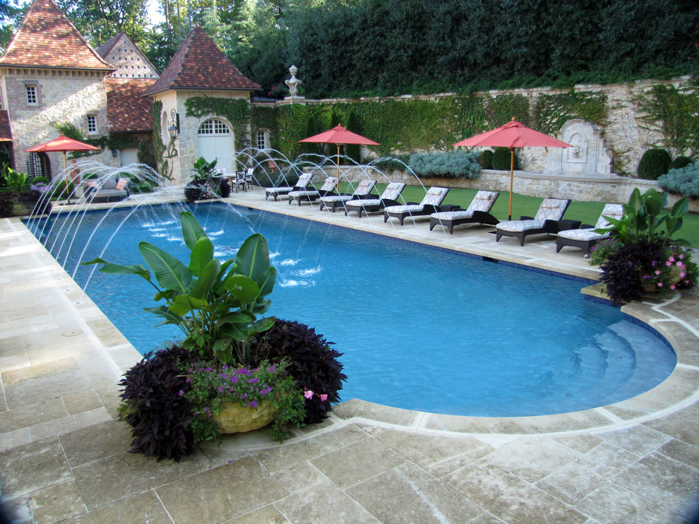 Modelo de piscina natural mediterránea grande rectangular en patio trasero con adoquines de piedra natural