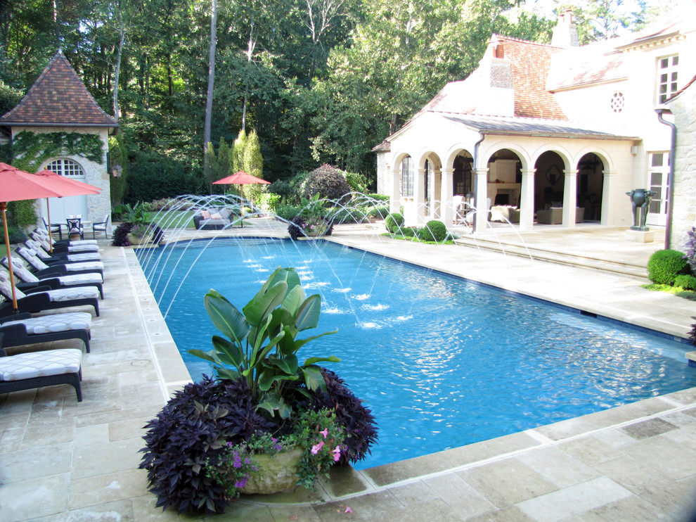 Idée de décoration pour une grande piscine naturelle et arrière méditerranéenne rectangle avec des pavés en pierre naturelle.