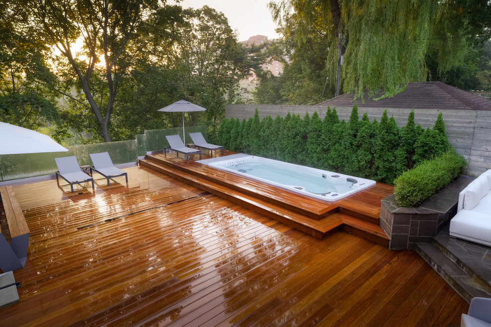 Cette photo montre un petit couloir de nage arrière moderne rectangle avec un bain bouillonnant et une terrasse en bois.