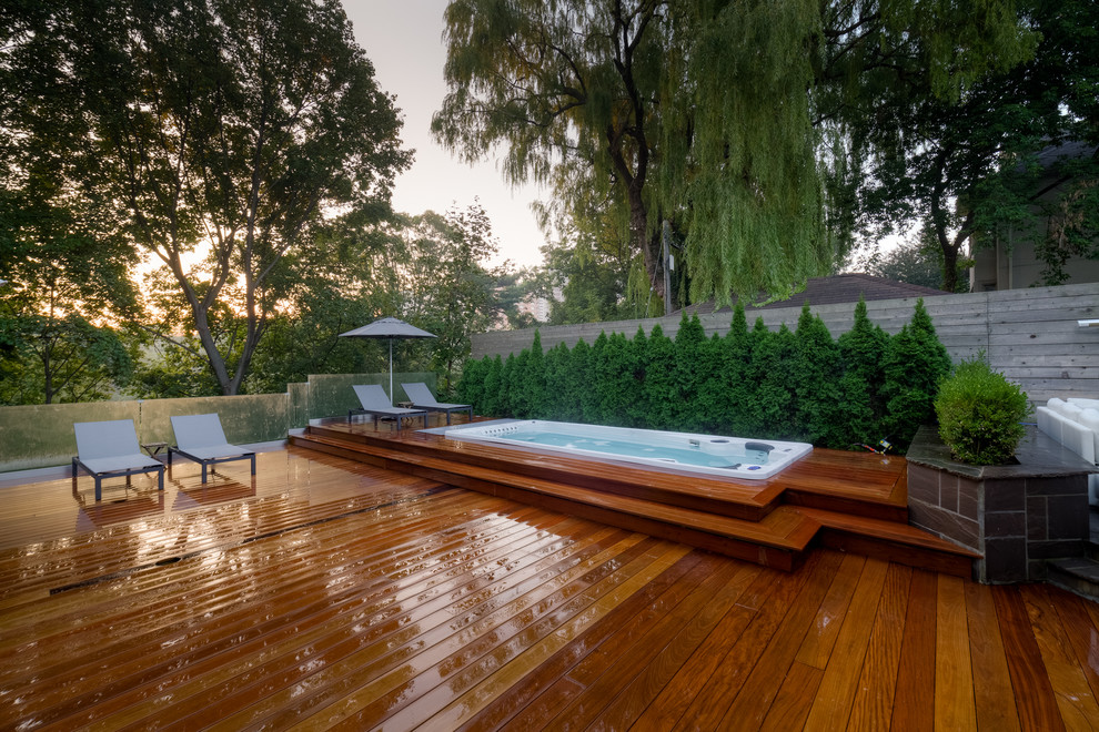 Esempio di una piccola piscina monocorsia moderna rettangolare dietro casa con una vasca idromassaggio e pedane