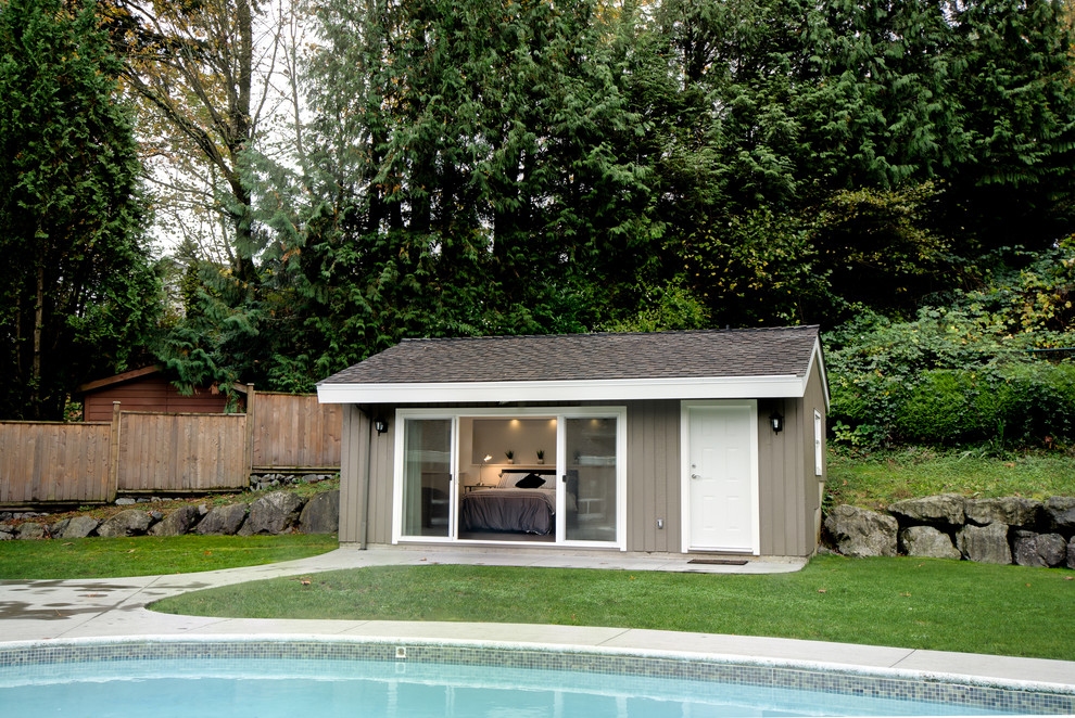 Ejemplo de casa de la piscina y piscina costera de tamaño medio tipo riñón en patio trasero con losas de hormigón