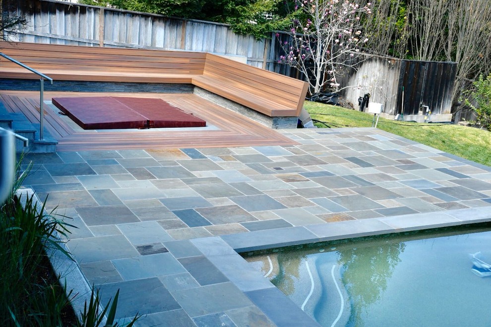 Diseño de piscinas y jacuzzis alargados clásicos renovados de tamaño medio rectangulares en patio trasero con suelo de baldosas