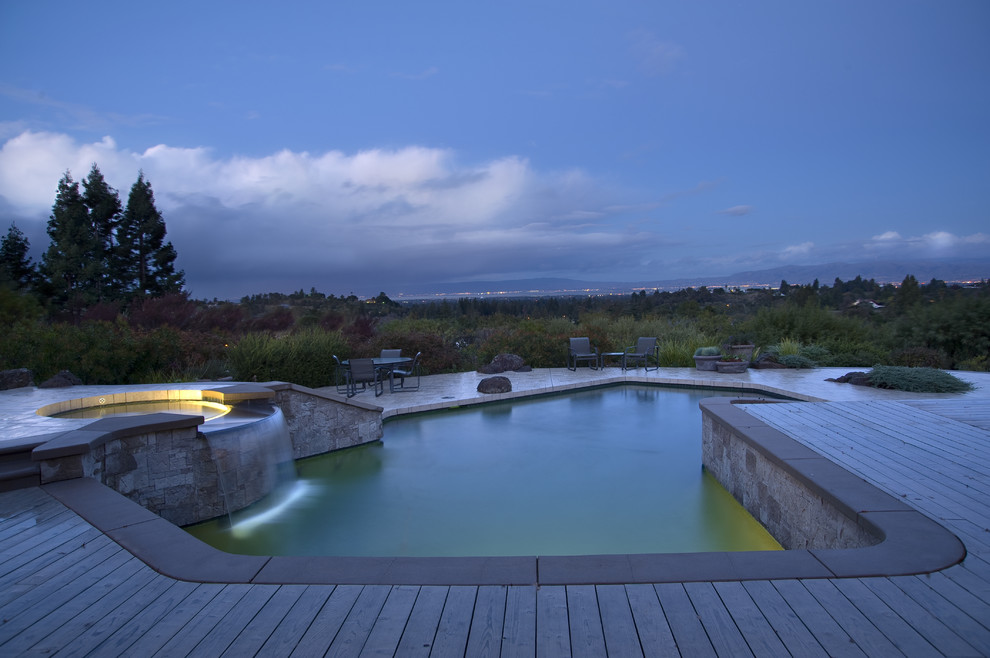 Exemple d'une piscine tendance sur mesure avec une terrasse en bois.
