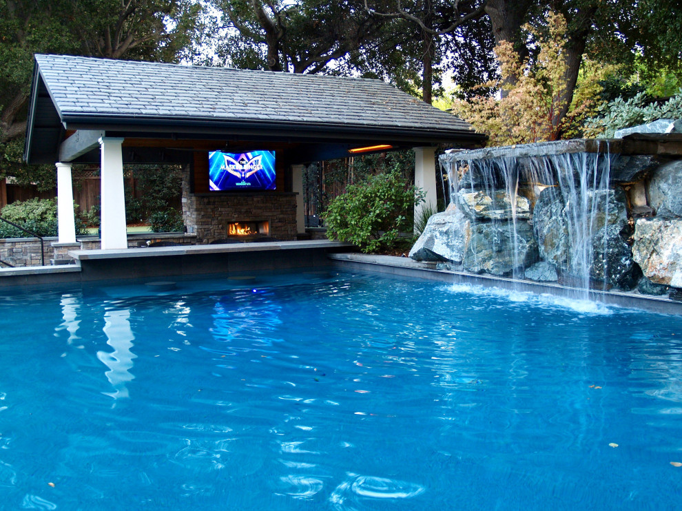 Foto di una piscina naturale stile americano rettangolare di medie dimensioni e dietro casa con paesaggistica bordo piscina e pavimentazioni in pietra naturale