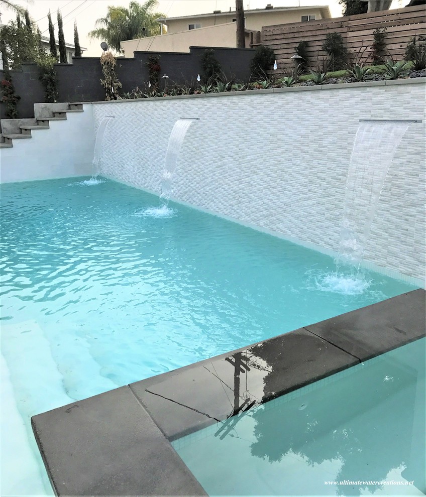 Pool - large backyard rectangular pool idea in Los Angeles with decking