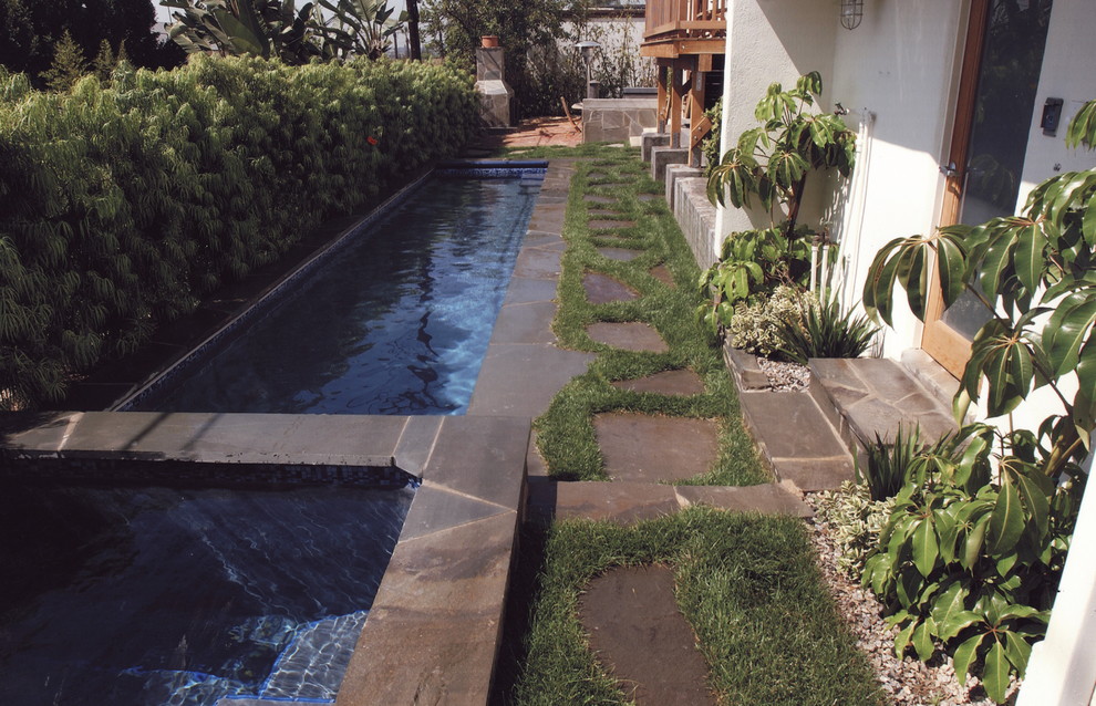 Ejemplo de piscinas y jacuzzis alargados actuales de tamaño medio rectangulares en patio lateral con adoquines de piedra natural