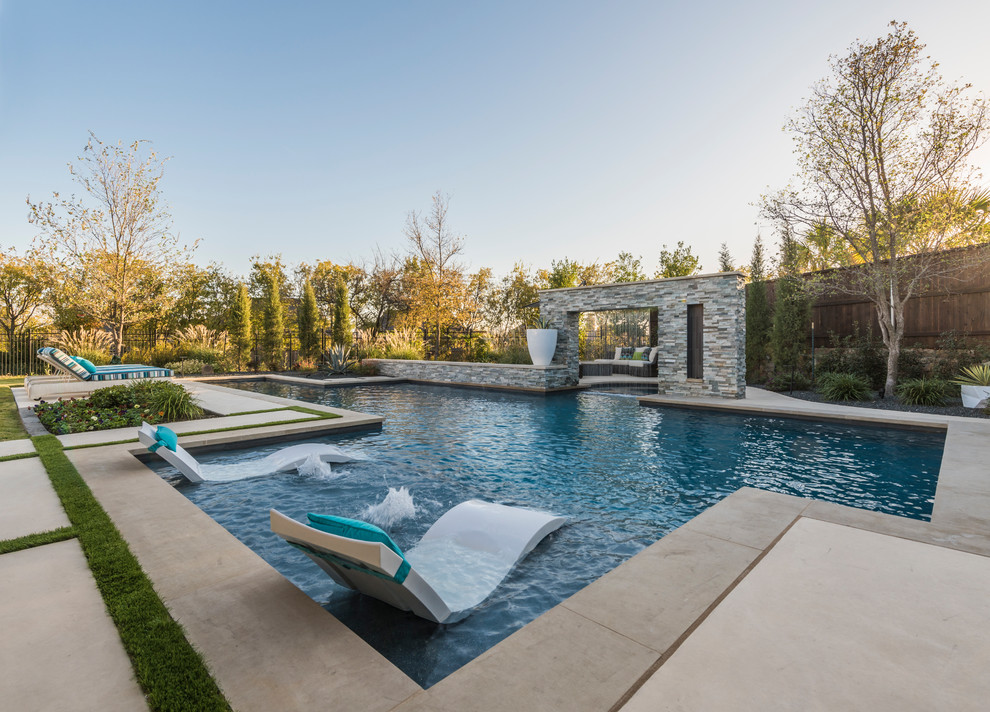 Foto de piscina con fuente alargada tradicional renovada grande a medida en patio trasero con losas de hormigón
