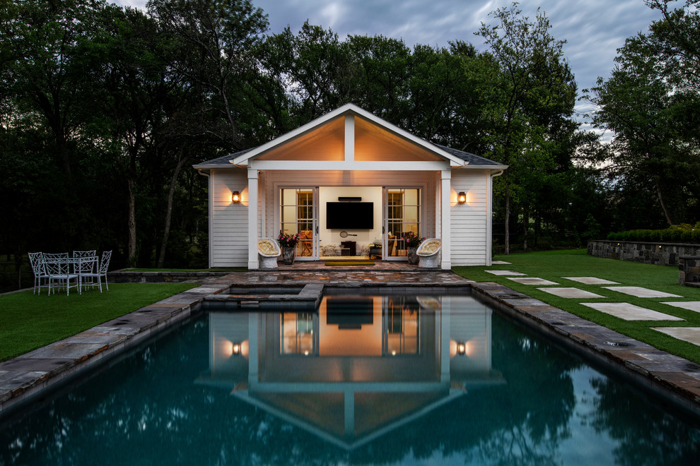 На фото: прямоугольный бассейн среднего размера на заднем дворе в стиле неоклассика (современная классика) с домиком у бассейна и мощением тротуарной плиткой