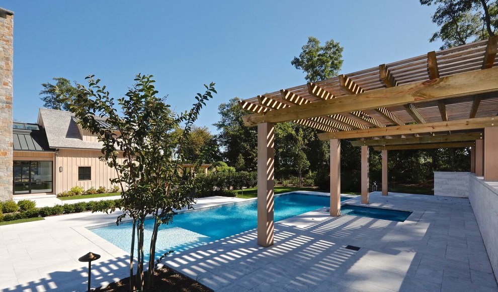 Esempio di una piscina monocorsia contemporanea rettangolare dietro casa con una vasca idromassaggio e pavimentazioni in pietra naturale