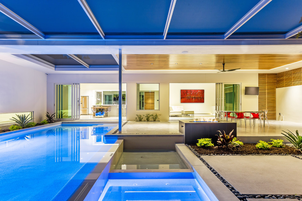 Idee per una piscina monocorsia minimalista personalizzata di medie dimensioni e dietro casa con pavimentazioni in cemento