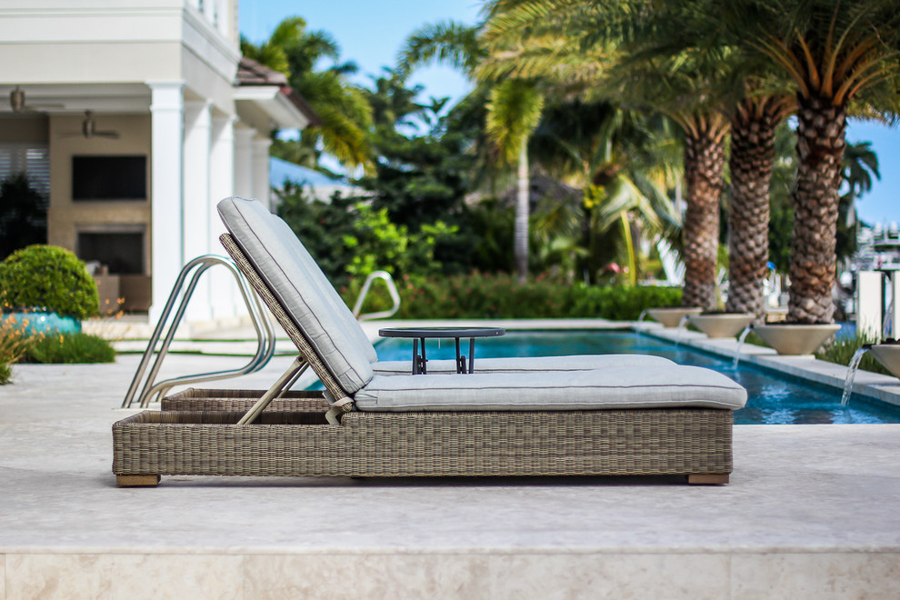 Modelo de piscina con fuente alargada moderna grande rectangular en patio trasero con adoquines de piedra natural