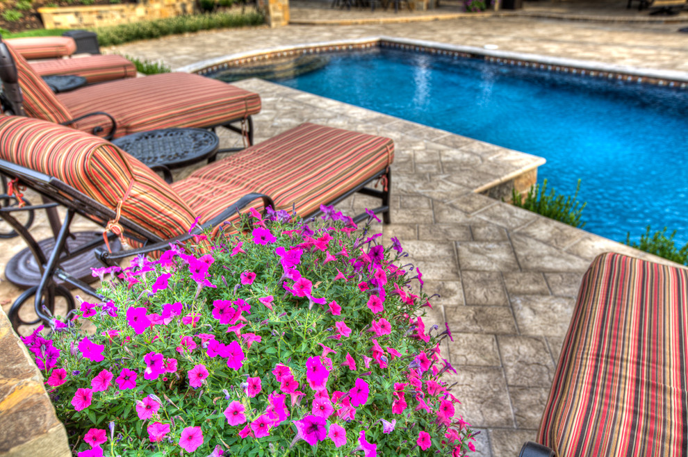 Ejemplo de piscina con fuente marinera de tamaño medio a medida en patio trasero con adoquines de piedra natural