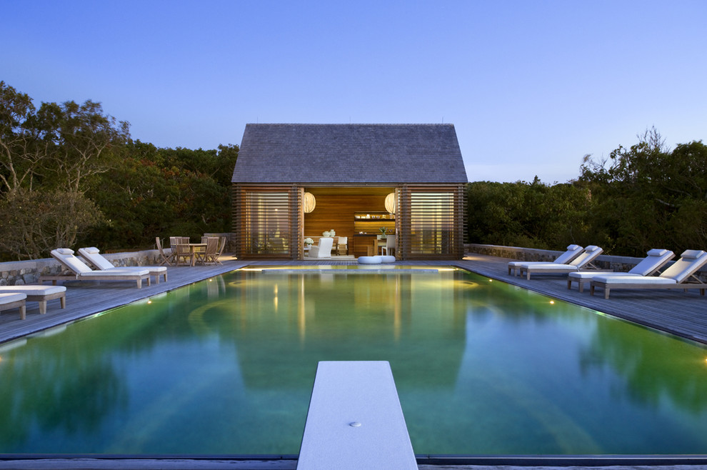 Immagine di una piscina a sfioro infinito stile marinaro rettangolare di medie dimensioni e dietro casa con una dépendance a bordo piscina e pedane