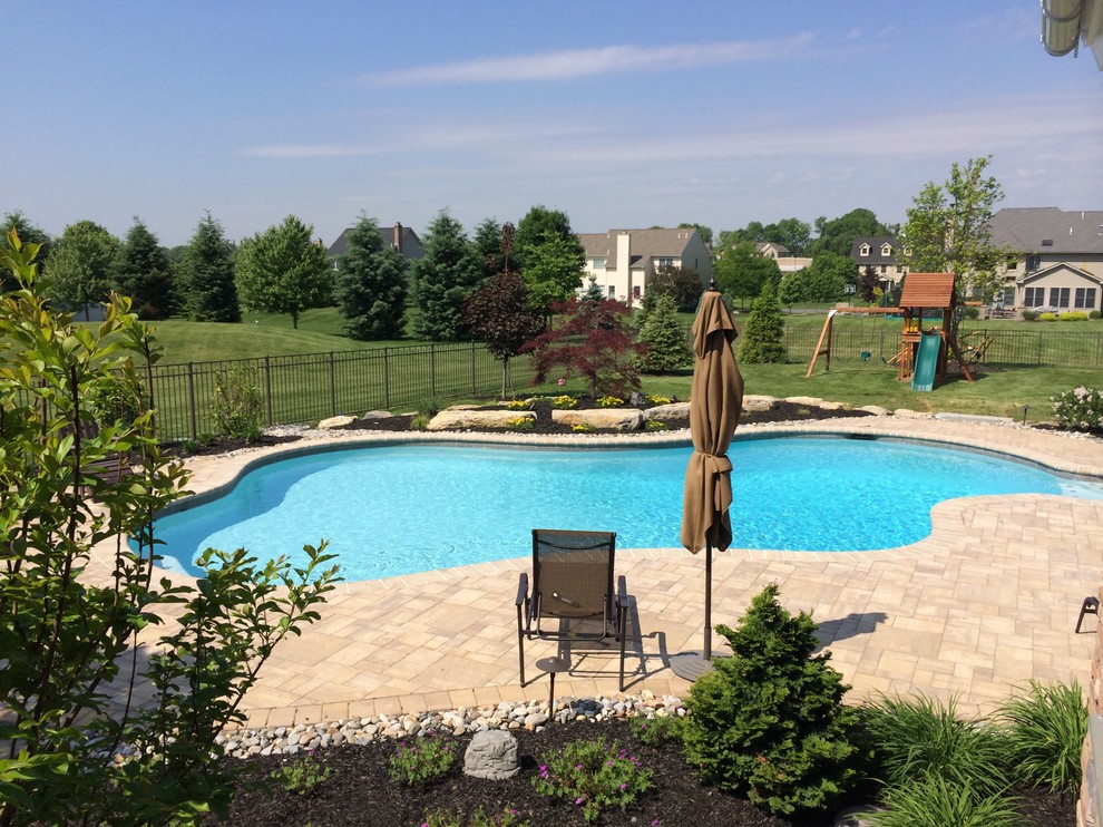 Elegant backyard custom-shaped and concrete paver natural pool photo in Philadelphia