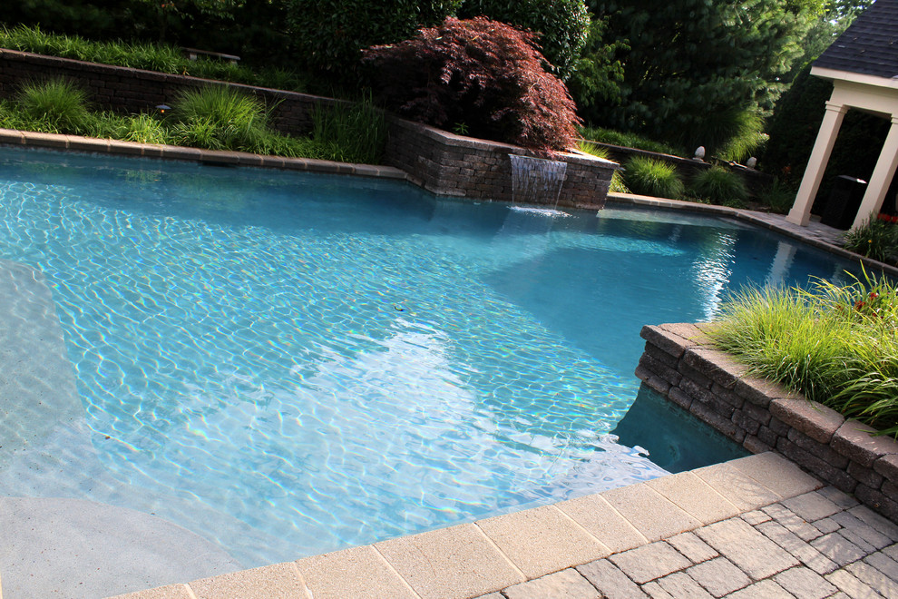 На фото: естественный, прямоугольный бассейн на заднем дворе в классическом стиле с мощением тротуарной плиткой