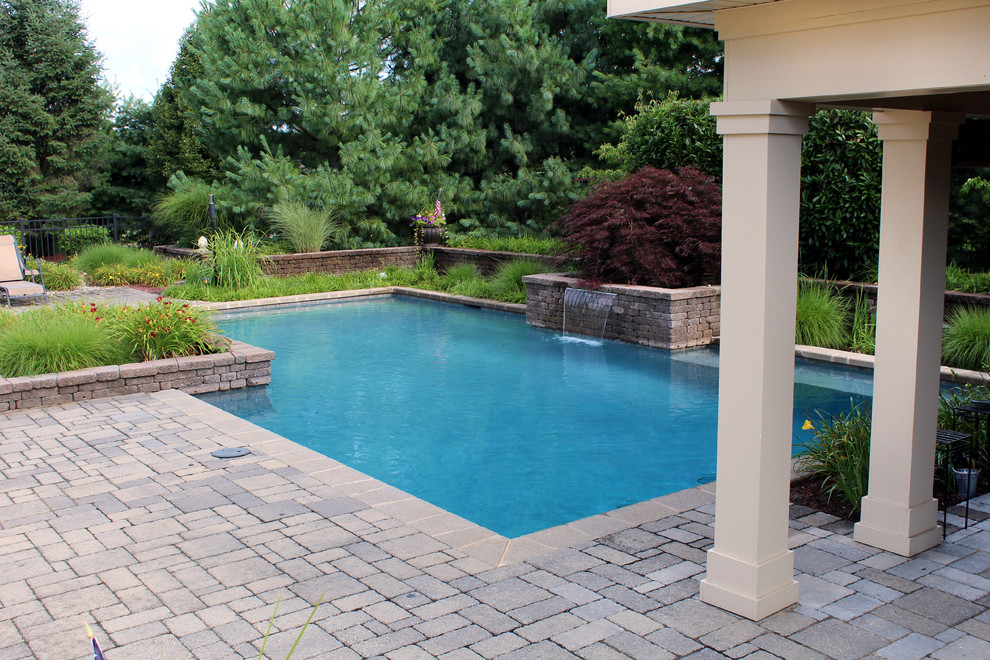 Idées déco pour une piscine naturelle et arrière classique rectangle avec des pavés en béton.