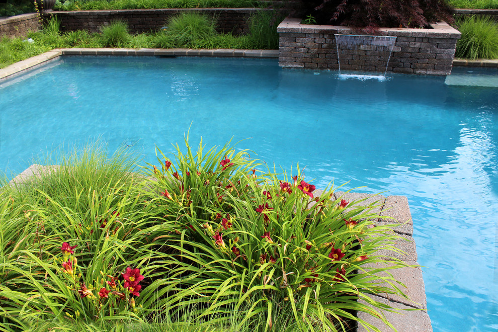 Example of a classic backyard concrete paver and rectangular natural pool design in Philadelphia