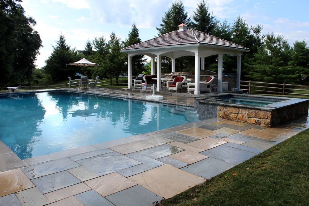 Design ideas for a classic back rectangular natural hot tub in Philadelphia with natural stone paving.