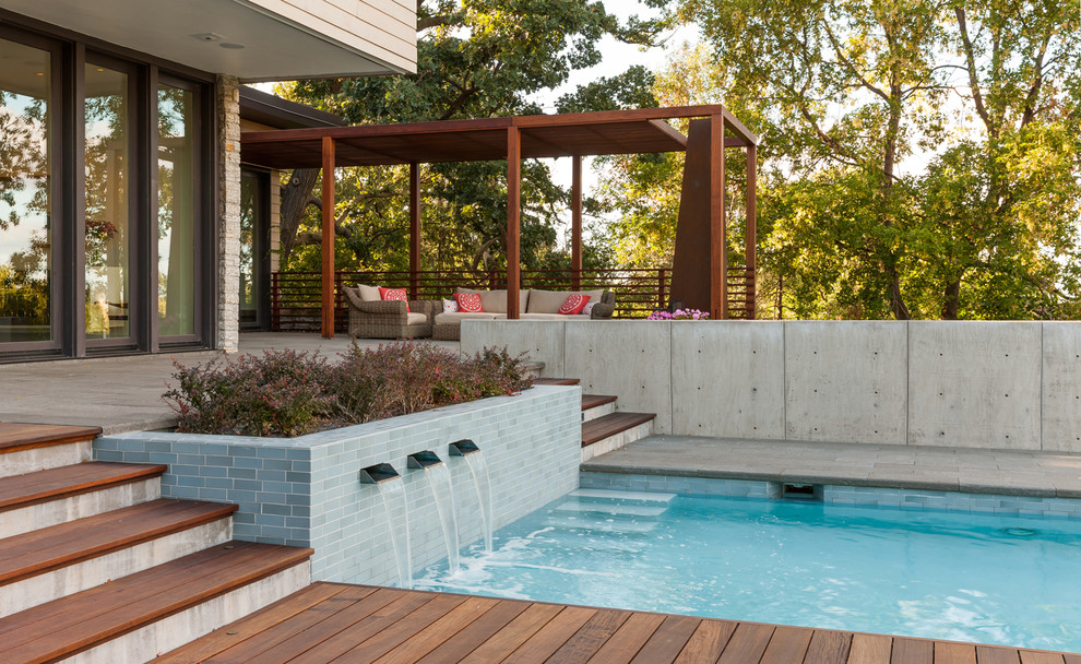 Aménagement d'une piscine arrière contemporaine rectangle avec une terrasse en bois.