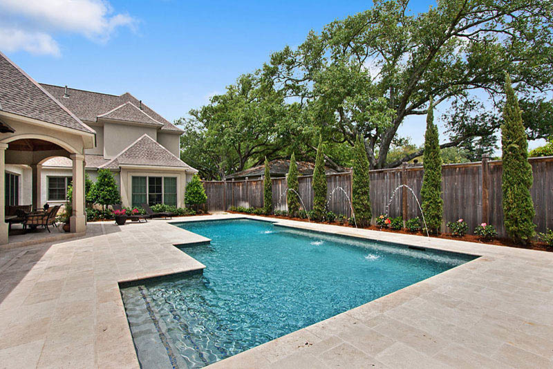 Medium sized classic back custom shaped swimming pool in New Orleans with a water feature and natural stone paving.