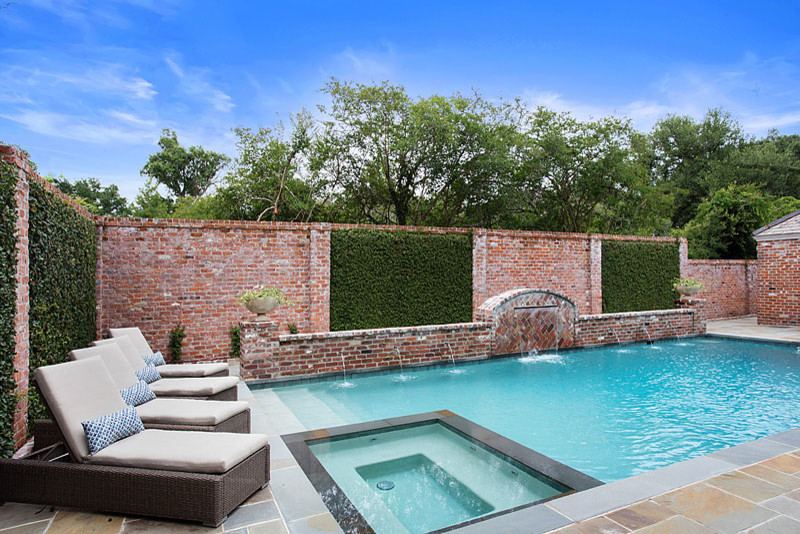 Mittelgroßer Klassischer Pool hinter dem Haus in rechteckiger Form mit Wasserspiel und Natursteinplatten in New Orleans