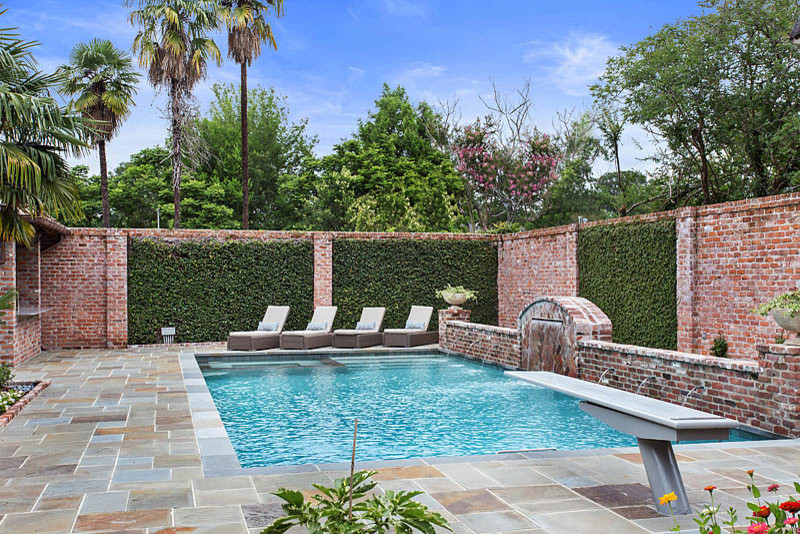 Diseño de piscina con fuente clásica de tamaño medio rectangular en patio trasero con adoquines de piedra natural