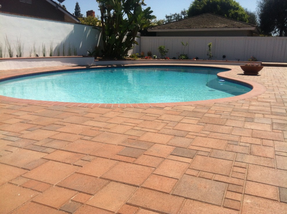 Foto de casa de la piscina y piscina alargada mediterránea grande a medida en patio trasero con suelo de baldosas