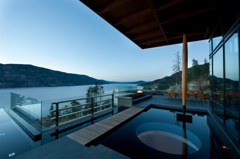 Inspiration for a mid-sized contemporary rooftop stone and custom-shaped infinity pool fountain remodel in Vancouver
