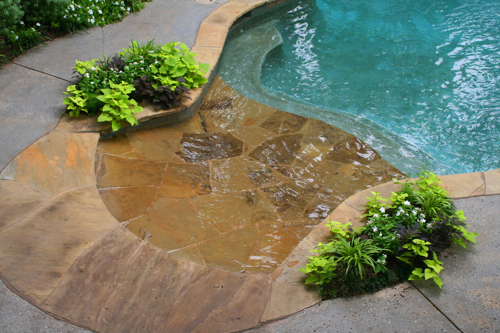 Design ideas for a large classic back custom shaped hot tub in Dallas with natural stone paving.