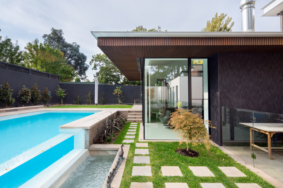 Ispirazione per una grande piscina fuori terra minimal rettangolare dietro casa con fontane e pavimentazioni in cemento