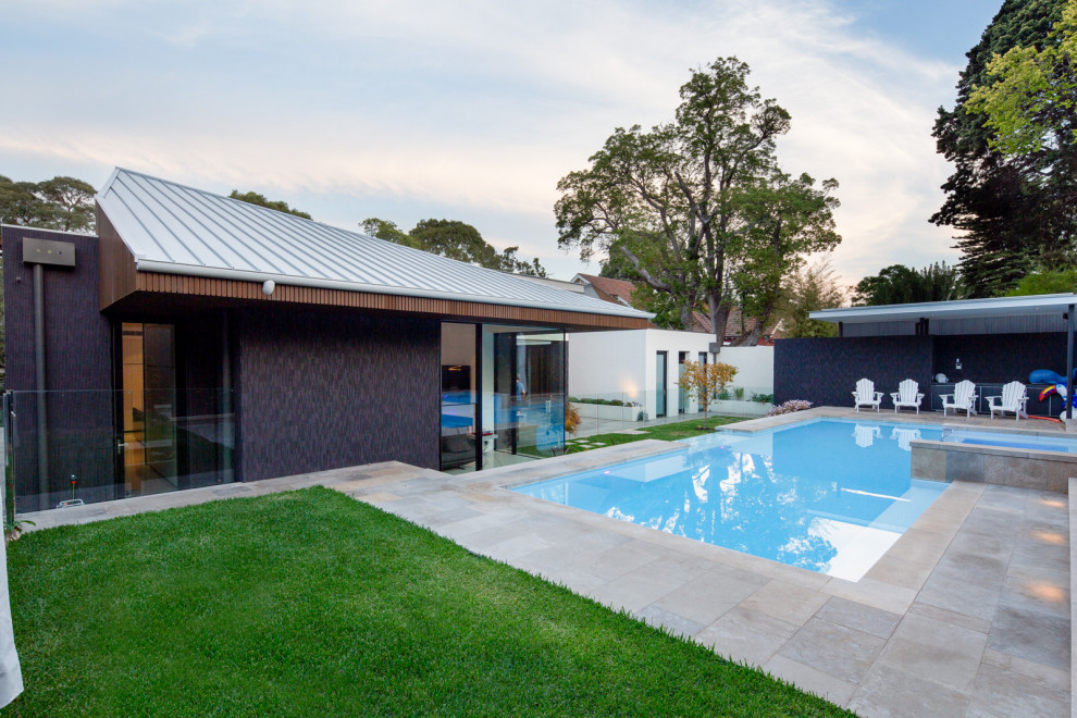 Immagine di una grande piscina minimal rettangolare dietro casa con fontane e pavimentazioni in cemento