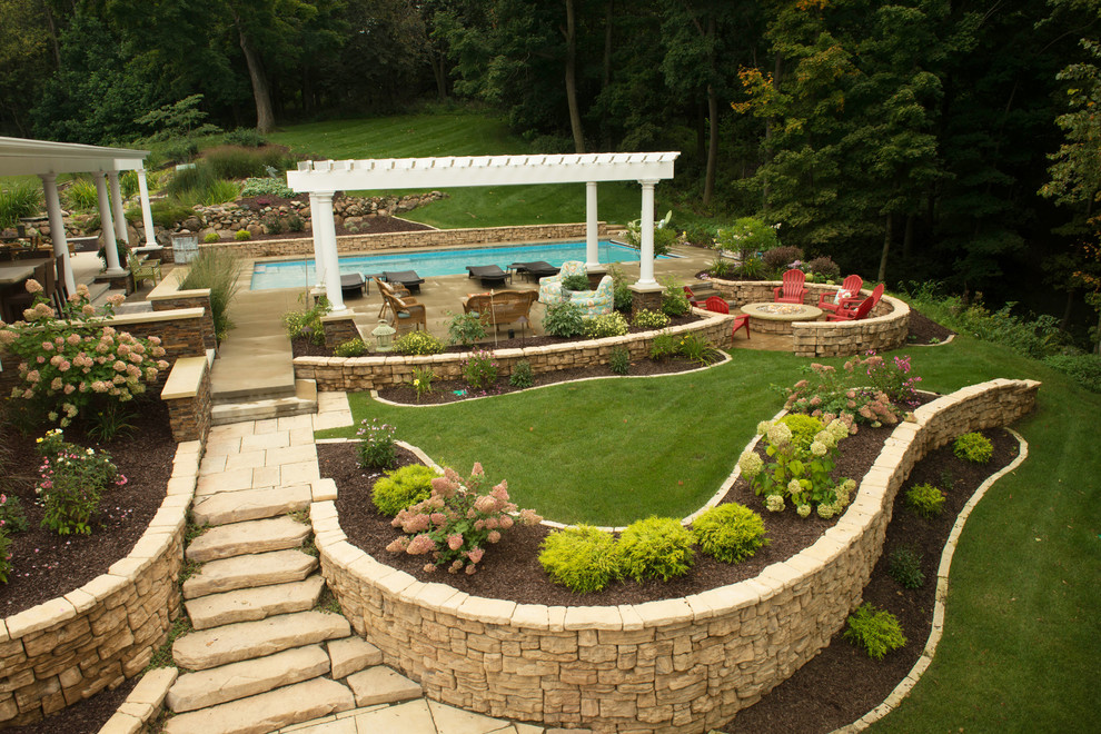На фото: большой прямоугольный бассейн на заднем дворе в стиле ретро с фонтаном и покрытием из бетонных плит с