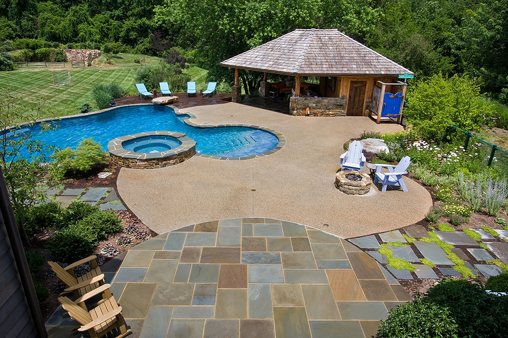 Inspiration for a large traditional back custom shaped lengths swimming pool in Baltimore with a pool house and natural stone paving.