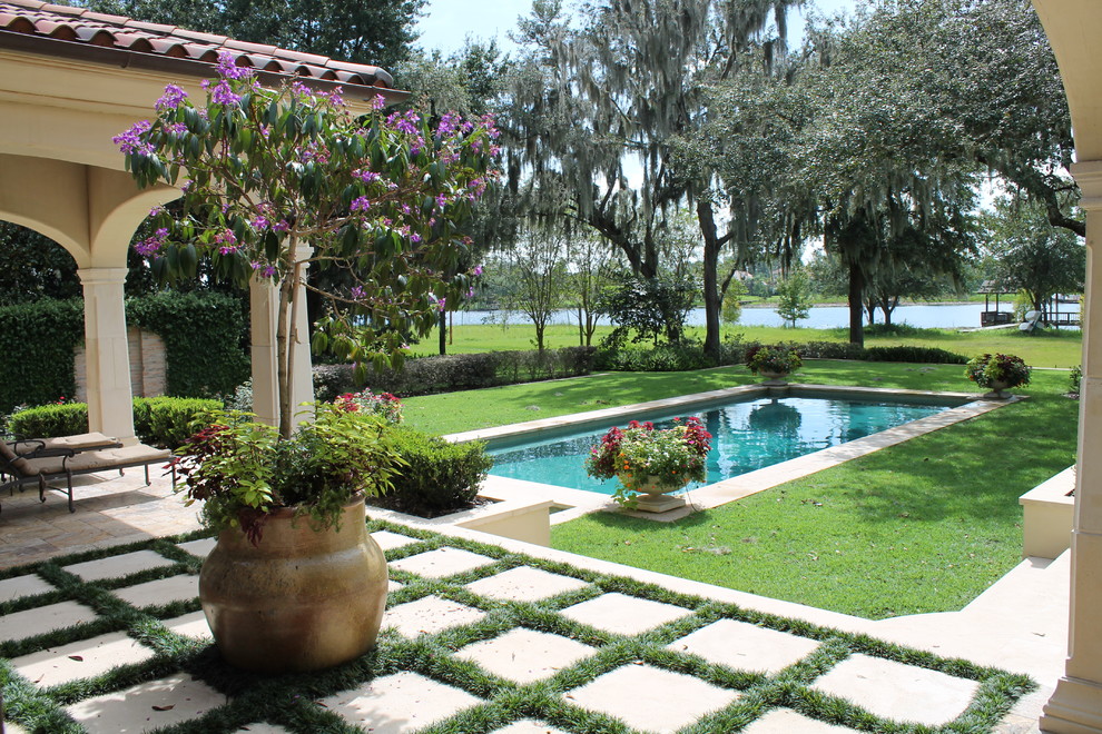 Foto på en mellanstor medelhavsstil pool på baksidan av huset, med naturstensplattor