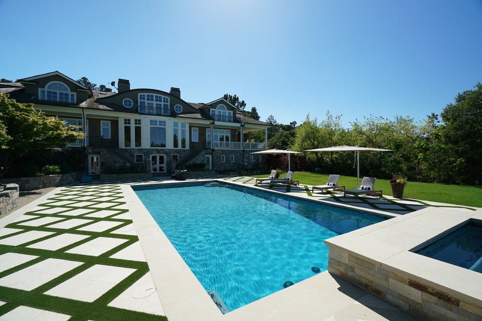 Imagen de piscina actual grande a medida en patio trasero con adoquines de piedra natural